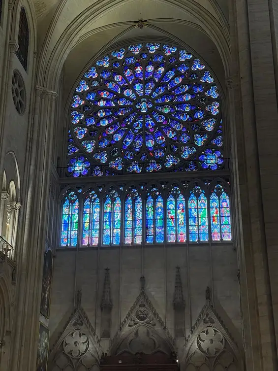 Deux instants suspendus : la flamme des Jeux et la lumière de Notre-Dame — La rosace flamboyante des vitraux.