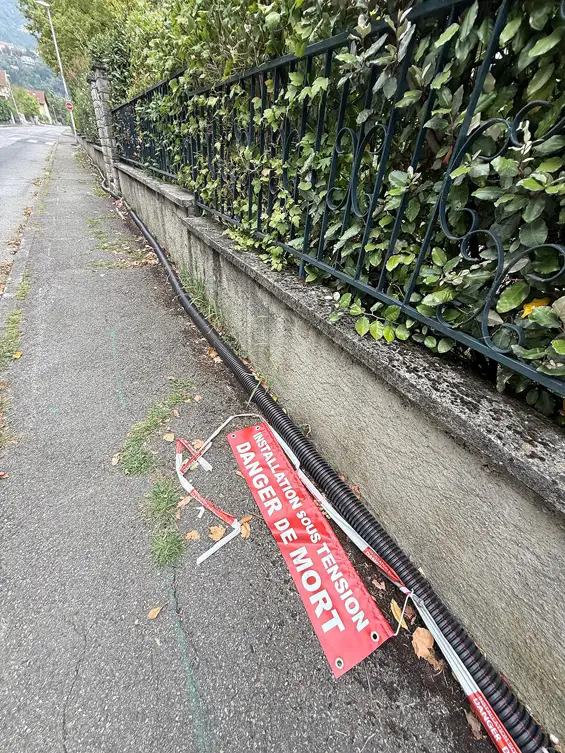 Rue du Pré d’Elle, une gaine électrique court depuis plusieurs semaines le long du trottoir. Sur un poteau, un avertissement « Danger de mort »