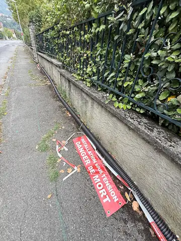 Rue du Pré d’Elle, une gaine électrique court depuis plusieurs semaines le long du trottoir. Sur un poteau, un avertissement « Danger de mort »